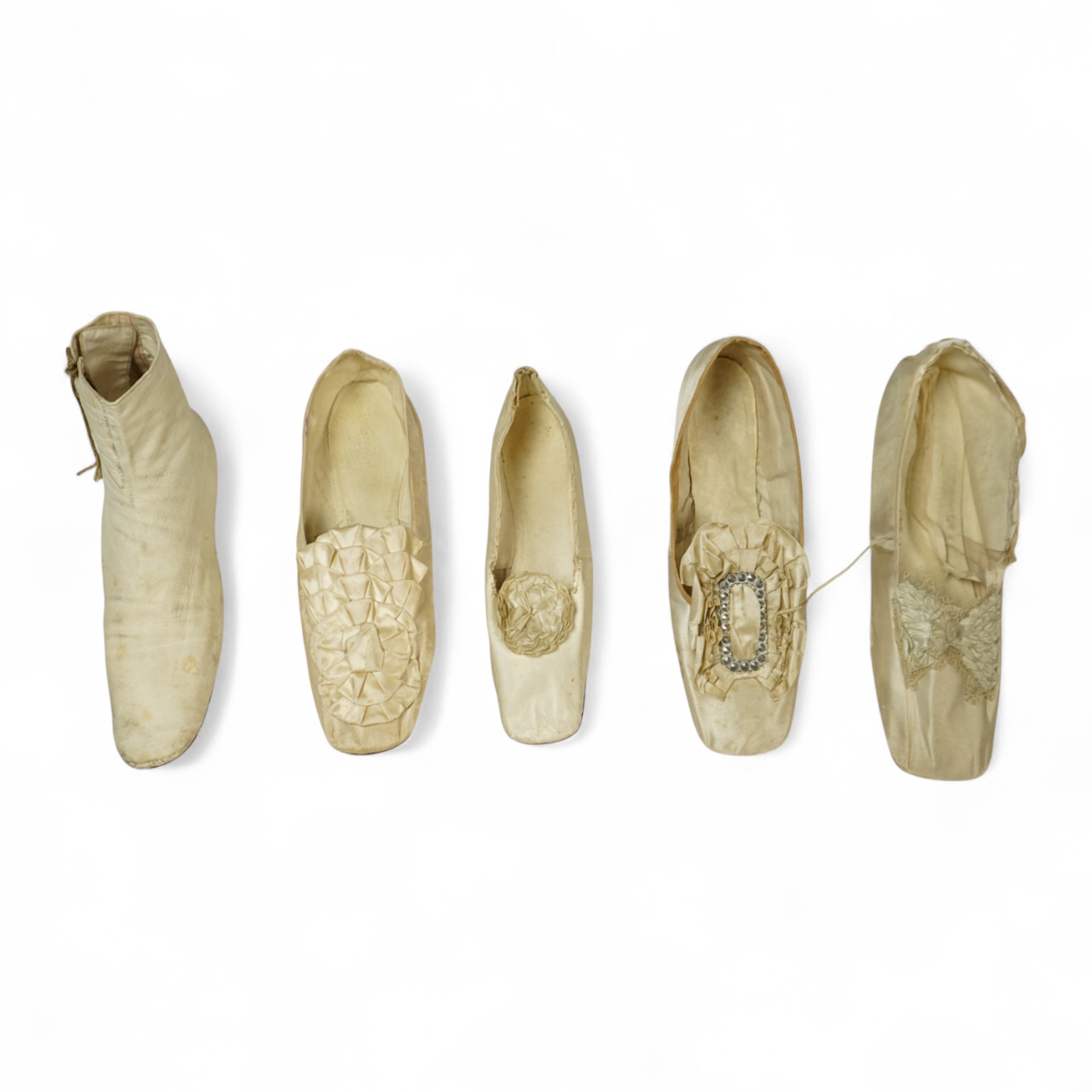 A 19th century hand made cream kid leather ladies ankle boot and four differing cream silk and satin single wedding shoes. All with leather soles. Possibly a traveller's sample range. Boots 24.5cm long (heel to toe). Con